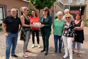 Burgemeester overhandigd de taart aan de bewoners