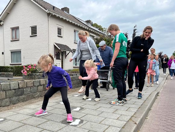 Kinderen doen een oefening op het trottoir.