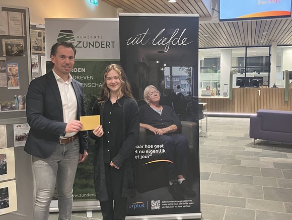 Wethouder reikt de waardebon uit aan Abby